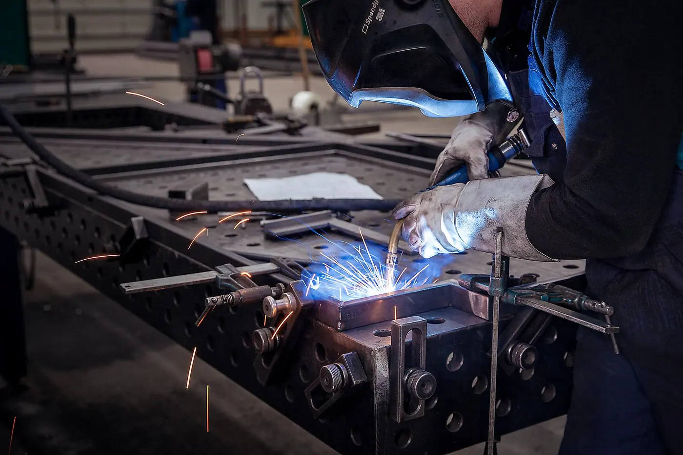 Lasser aan het werk in de werkplaats van Hektracon